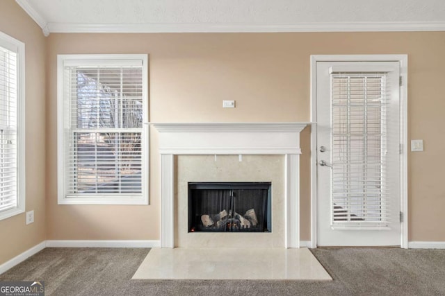 unfurnished living room with baseboards, carpet floors, a premium fireplace, and crown molding