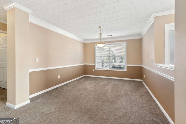 spare room featuring a textured ceiling, carpet flooring, baseboards, ornamental molding, and decorative columns