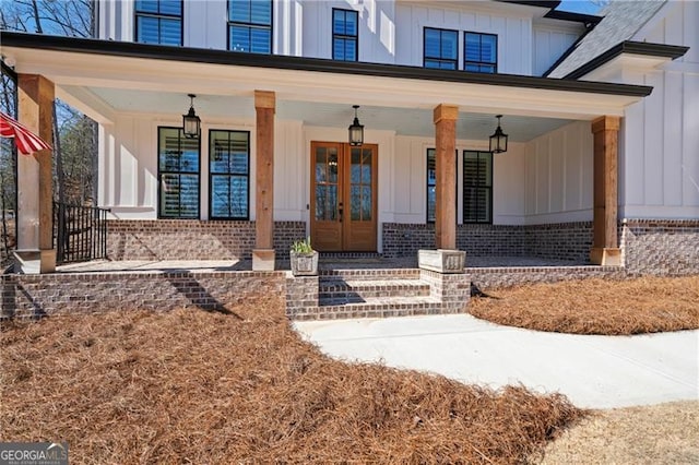 6326 Point Twenty Two, Gainesville, GA 30506 - view of exterior entry with covered porch, brick siding, board and batten siding, and french doors