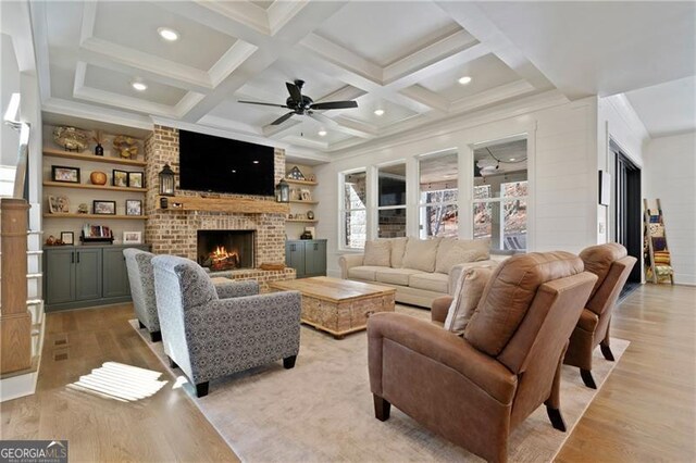 living area featuring a brick fireplace, coffered ceiling, beamed ceiling, and light wood finished floors