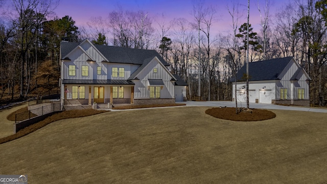 modern farmhouse style home with board and batten siding, a standing seam roof, curved driveway, and metal roof