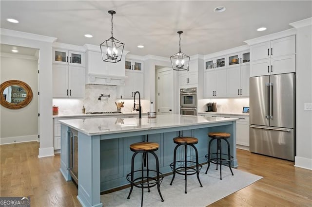 kitchen featuring stainless steel appliances, ornamental molding, and white cabinets