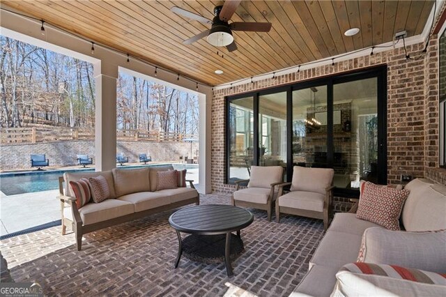 view of patio featuring a ceiling fan, an outdoor hangout area, and a fenced in pool