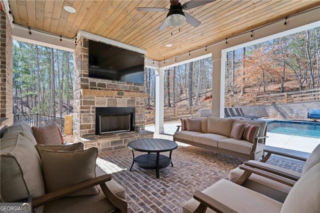 view of patio with a fenced in pool, ceiling fan, an outdoor living space with a fireplace, and fence