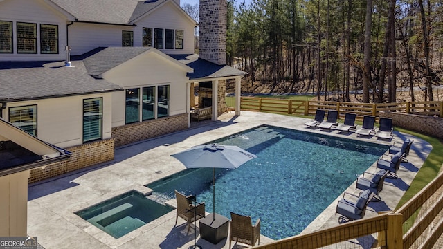 view of swimming pool featuring an in ground hot tub, a patio area, fence, and a fenced in pool