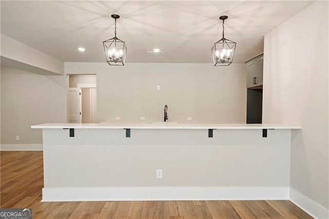 6326 Point Twenty Two, Gainesville, GA 30506 - kitchen featuring an inviting chandelier, a kitchen breakfast bar, light countertops, and light wood finished floors