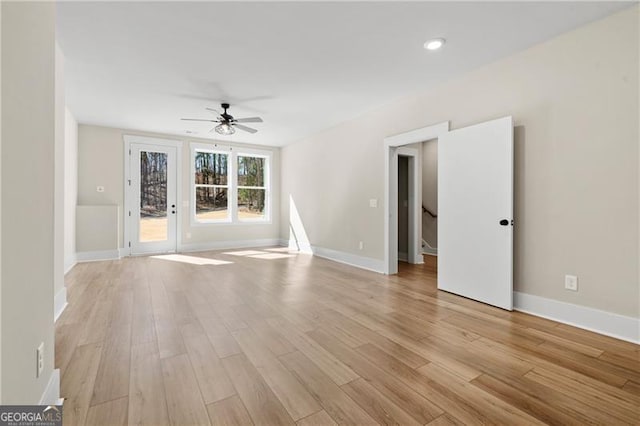 unfurnished room featuring light wood-type flooring, baseboards, and a ceiling fan