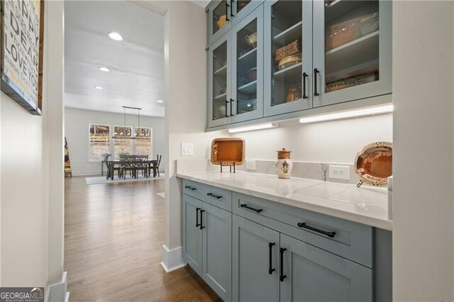 bar featuring baseboards, dark wood-type flooring, and recessed lighting