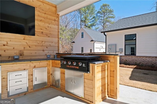 view of patio featuring exterior kitchen and a grill