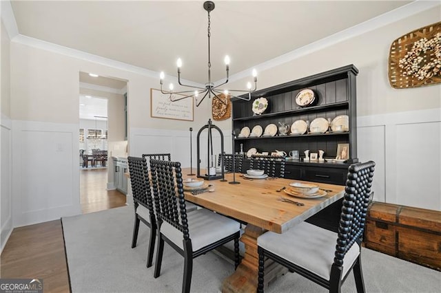 6326 Point Twenty Two, Gainesville, GA 30506 - dining space featuring a chandelier, ornamental molding, wainscoting, wood finished floors, and a decorative wall