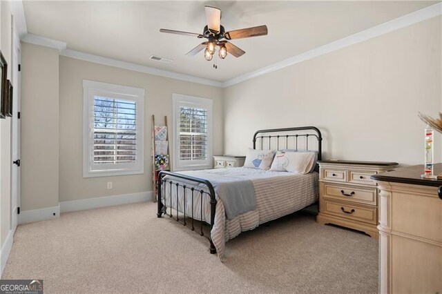 bedroom featuring baseboards, visible vents, crown molding, and light colored carpet