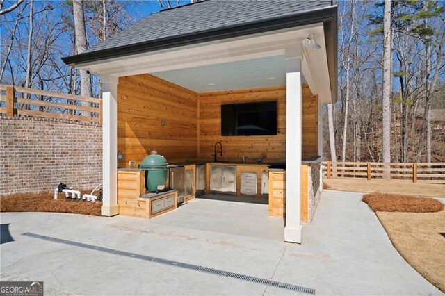 exterior space featuring fence and exterior kitchen