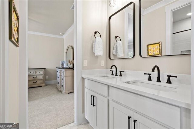 bathroom featuring double vanity, crown molding, and a sink