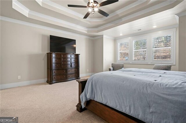 carpeted bedroom featuring crown molding, ceiling fan, a tray ceiling, and baseboards