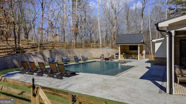 view of swimming pool with a fenced backyard, an outdoor structure, a fenced in pool, and a patio