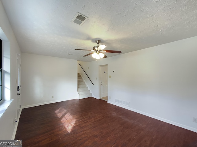 spare room featuring stairs, wood finished floors, visible vents, and baseboards