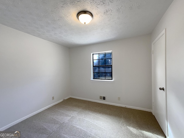 unfurnished bedroom with a textured ceiling, carpet, visible vents, and baseboards