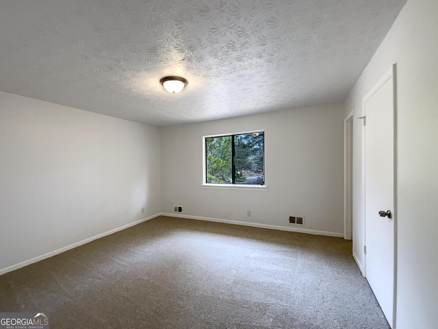 unfurnished bedroom featuring a textured ceiling, carpet floors, visible vents, and baseboards