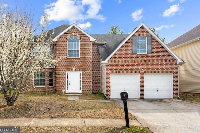 traditional-style home featuring driveway, roof with shingles, an attached garage, and brick siding