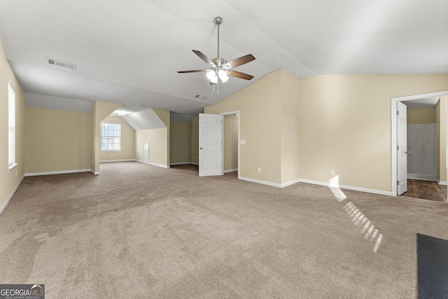 additional living space featuring lofted ceiling, a ceiling fan, visible vents, baseboards, and carpet