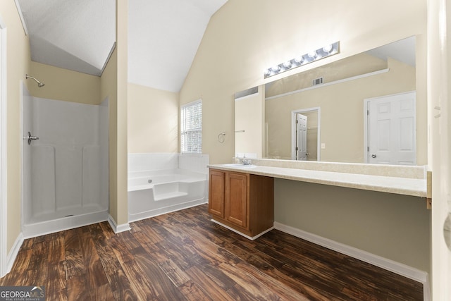 bathroom with a garden tub, wood finished floors, visible vents, vaulted ceiling, and walk in shower