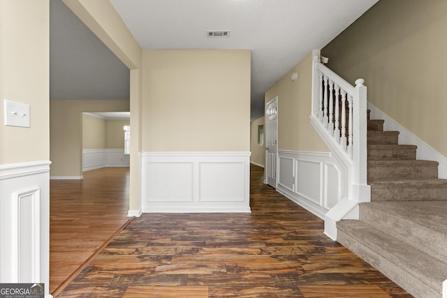 interior space featuring visible vents, wood finished floors, and wainscoting