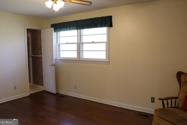 unfurnished bedroom featuring dark wood-style flooring, visible vents, and baseboards