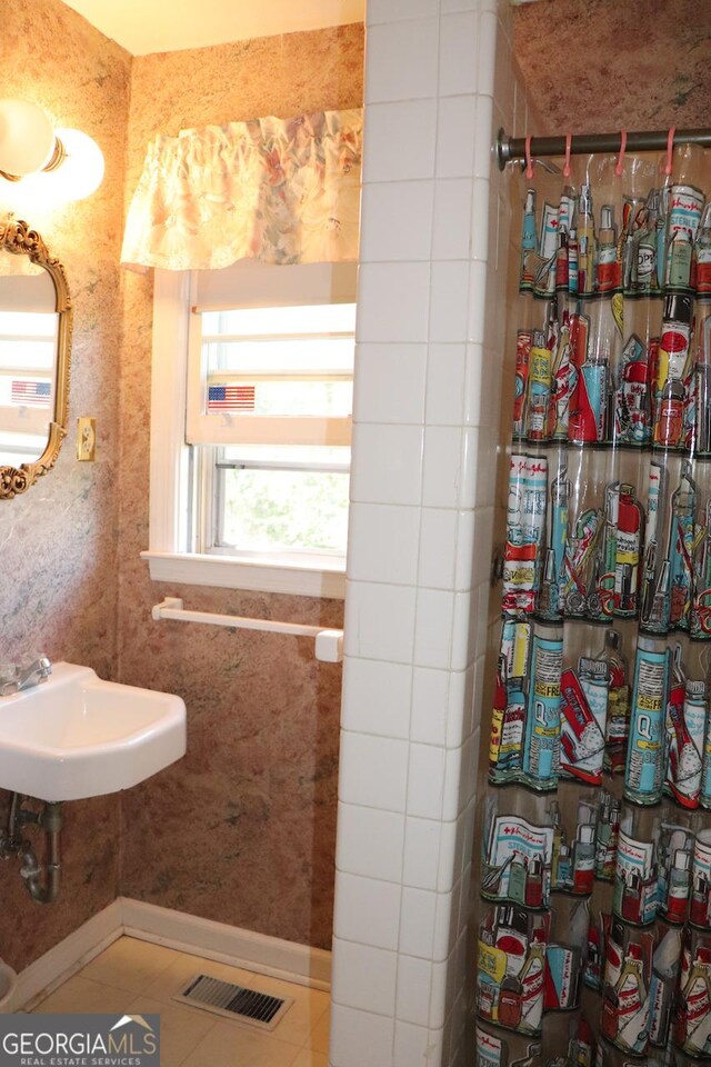 bathroom featuring visible vents, a sink, and tile patterned floors