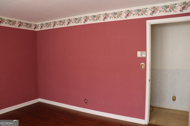 empty room featuring baseboards and wood finished floors