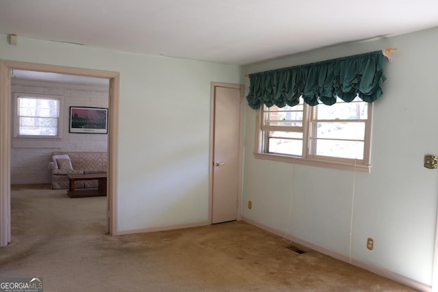 unfurnished bedroom with baseboards, visible vents, and light colored carpet