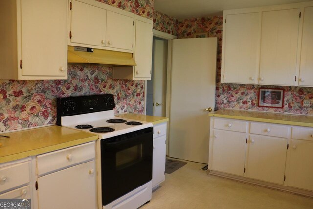 kitchen featuring light floors, light countertops, electric range, under cabinet range hood, and wallpapered walls