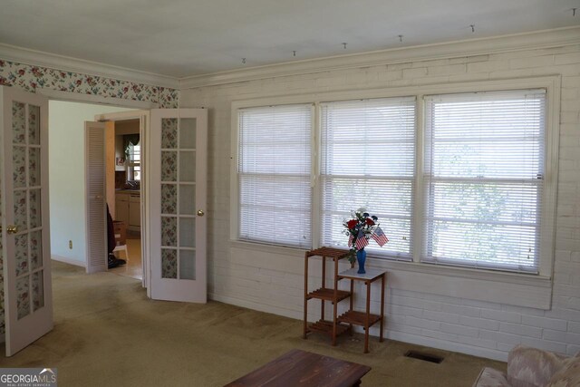 interior space featuring visible vents, french doors, crown molding, and light colored carpet