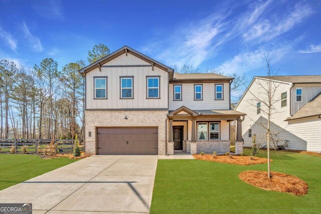 view of front of home with concrete driveway, fence, a front lawn, board and batten siding, and brick siding