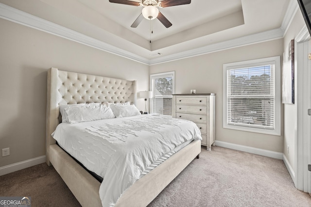 carpeted bedroom with a tray ceiling, multiple windows, and baseboards