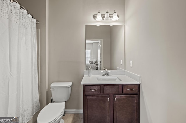 ensuite bathroom with toilet, vanity, ensuite bath, tile patterned flooring, and baseboards