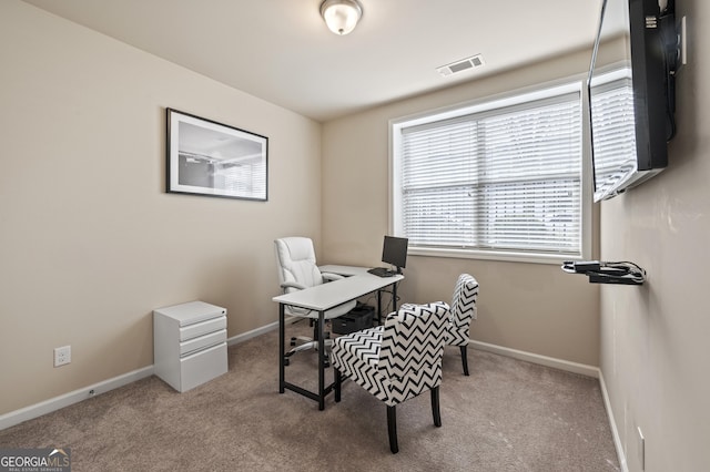 office area with visible vents, light carpet, and baseboards