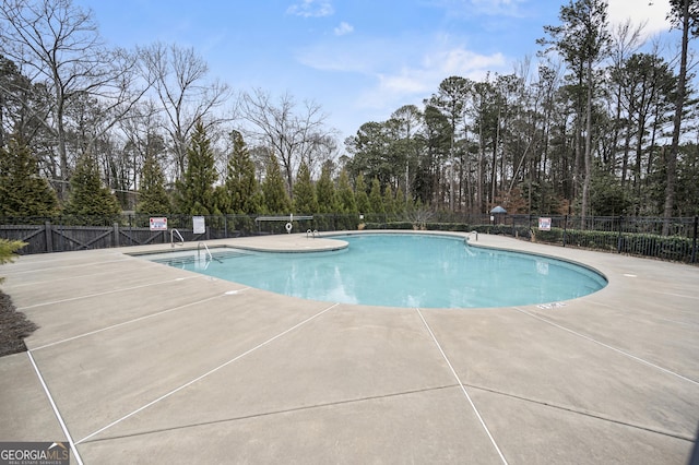 community pool featuring a patio area and fence