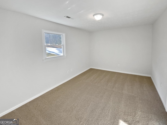 carpeted empty room featuring baseboards and visible vents