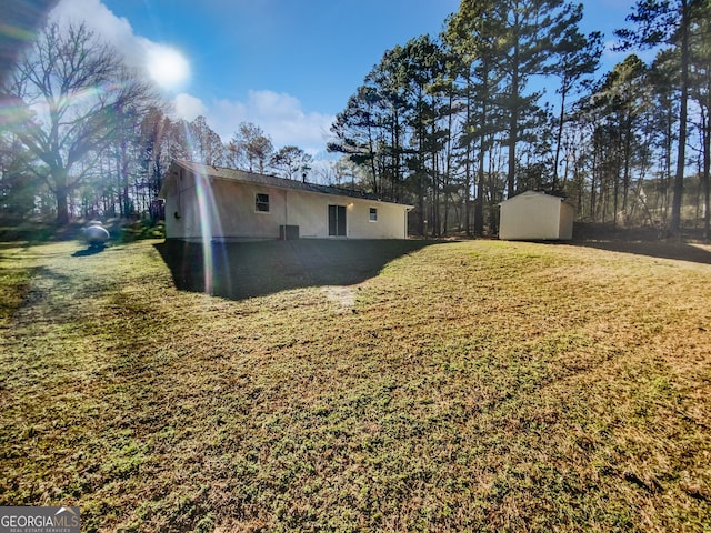 exterior space with a storage shed, a lawn, and an outbuilding