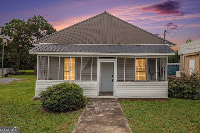 view of front of home featuring metal roof and a front yard