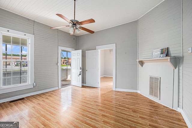 interior space with a fireplace, visible vents, ceiling fan, and light wood finished floors