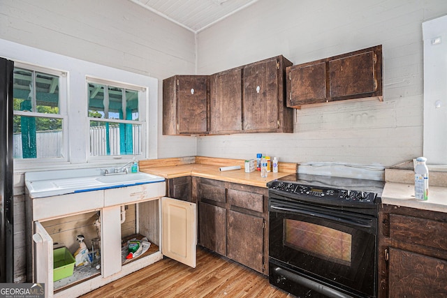 kitchen with dark brown cabinetry, light countertops, and black electric range oven