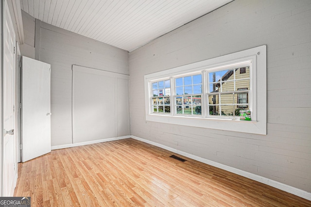 unfurnished bedroom featuring baseboards, visible vents, wood ceiling, light wood-type flooring, and a closet