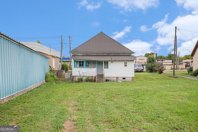 back of house with entry steps and a lawn