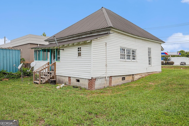 view of property exterior with crawl space, metal roof, and a lawn