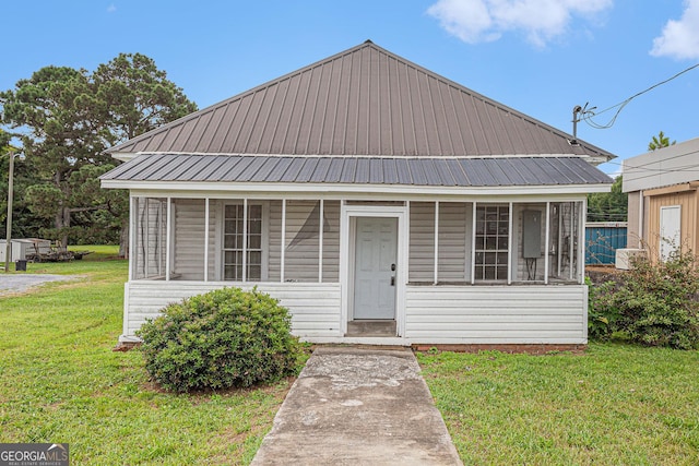 bungalow featuring a front yard and metal roof