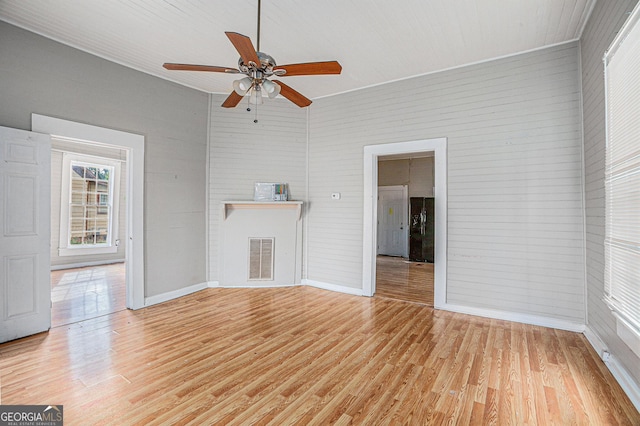 unfurnished living room featuring ceiling fan, light wood finished floors, visible vents, and baseboards