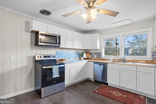 kitchen featuring stainless steel appliances, light countertops, white cabinets, and visible vents