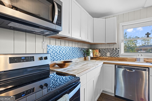 kitchen with stainless steel appliances, backsplash, white cabinets, and wood counters