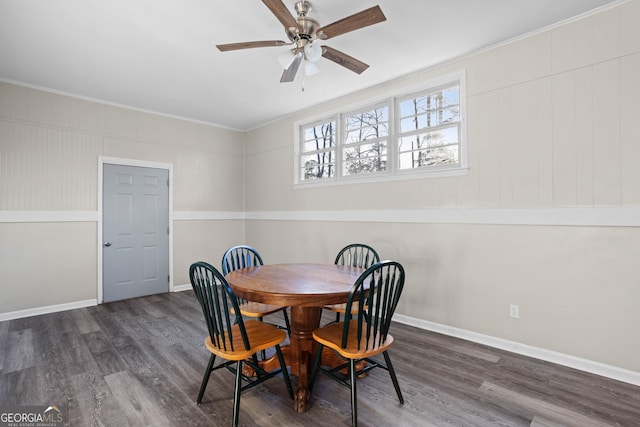 dining area featuring dark wood-type flooring, crown molding, baseboards, and ceiling fan